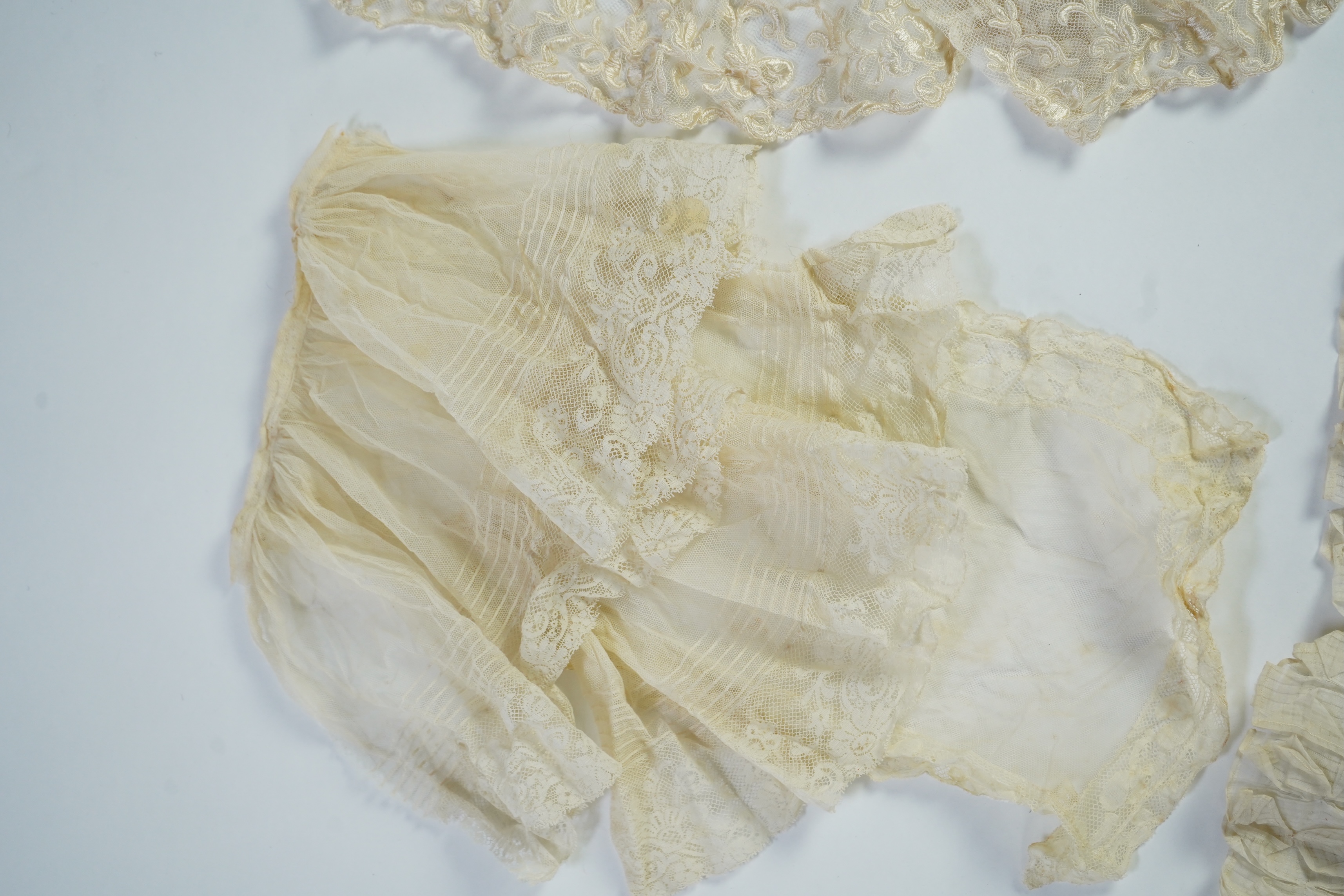 A suitcase containing a cream silk lace skirt to a dress, an Edwardian silk petticoat and various collars, possibly for theatrical use, silk petticoat 96 cm long. Condition - fair